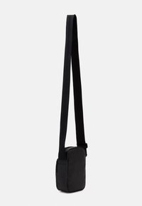 Borsa a spalla nera con superficie liscia, forma rettangolare, tracolla regolabile e chiusura con zip. Design minimalista, senza motivi visibili.