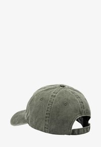 Zielona bawełniana czapka bejsbolowa z wygiętym daszkiem, widocznym przeszyciem, regulowanym paskiem z tyłu oraz miękką, teksturowaną powierzchnią.