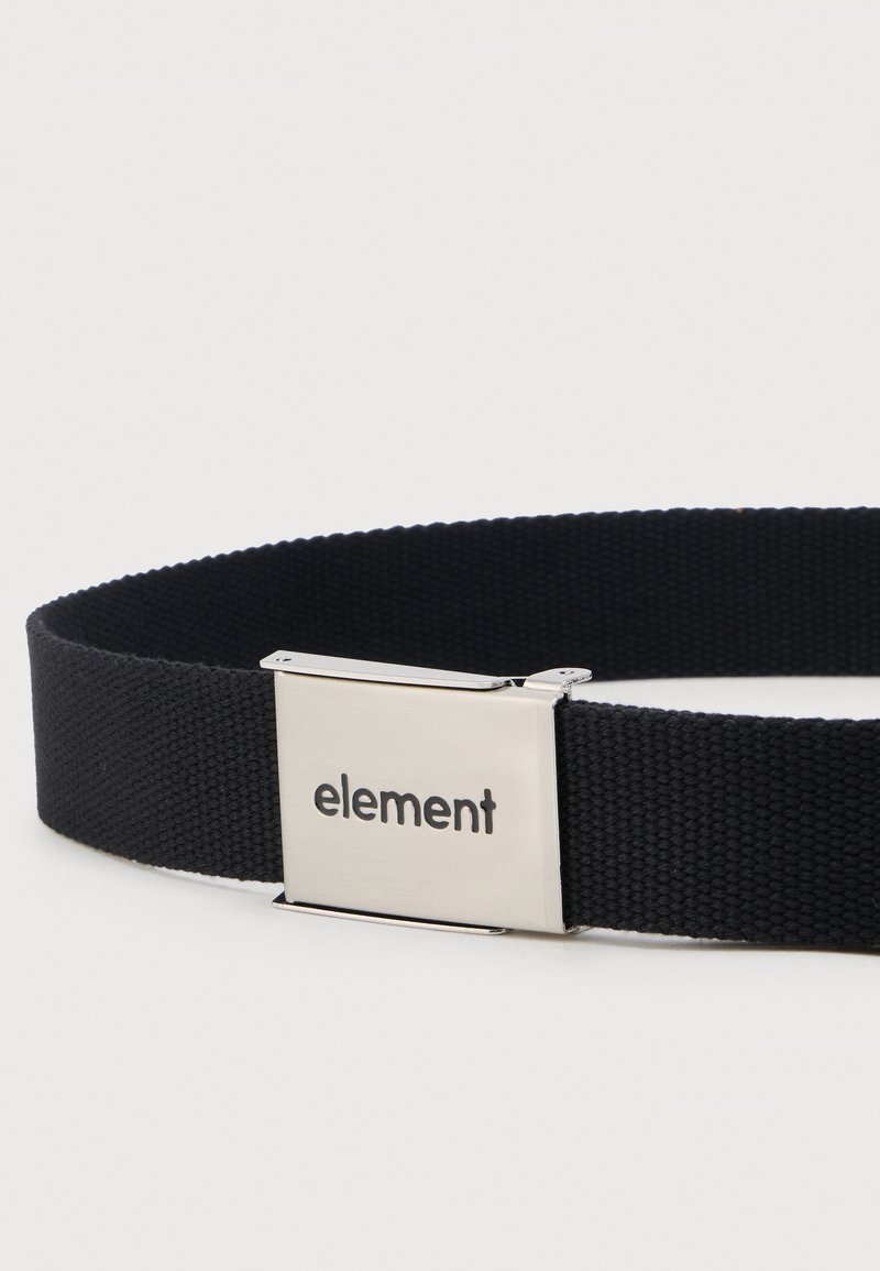 Ceinture en tissu noir avec boucle en métal argenté gravée du mot « element » sur fond blanc uni.