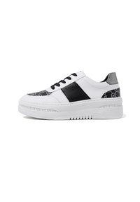 Sneaker bianca con una striscia in pelle nera, lacci neri e un pannello a motivi neri e bianchi testurizzati sulla punta. Suola spessa.