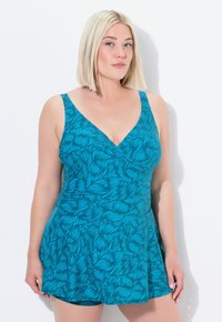 Teal tankini plavky s designem do V, se vzorem listů a rozšířenou sukní. Vyrobeno z hladkého a elastického materiálu.