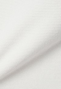 Nahaufnahme von weißem Textilgewebe mit einem kleinen, sich wiederholenden gewebten Muster und sanften Falten.