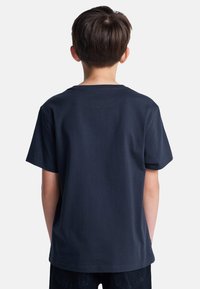 Marineblauwe katoenen t-shirt met korte mouwen en een ronde hals, van achteren weergegeven, met een gladde textuur en een comfortabele pasvorm.