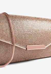 Rožinio aukso delninė su tekstūruota paviršiumi, dekoruota rhinestones, su metaliniu akcentu ir plona petneša. Geometrinis dizainas.