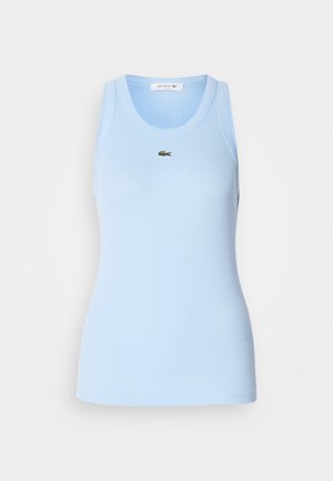 Top sans manches bleu clair en tissu côtelé, avec un col rond et un petit logo vert Lacoste sur la poitrine. Texture lisse.