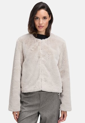 Veste en fausse fourrure beige clair avec un col rond, des manches longues et une coupe décontractée. Le tissu a une apparence douce et texturée.