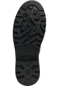 Suela de zapato de goma negra con un patrón de relieve, que presenta acentos circulares y en forma de estrella, además del logo en relieve "GEOX".