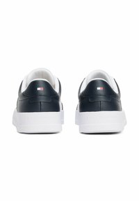 Sneakers in pelle blu con suola bianca, caratterizzati da un piccolo logo dettaglio sul tallone e una superficie liscia. Design minimalista con collare imbottito.