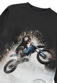 Camiseta neagră cu un grafic al unui motociclist pe o motocicletă albastră, înconjurat de stropi de noroi, având un design dinamic și accente detaliate.