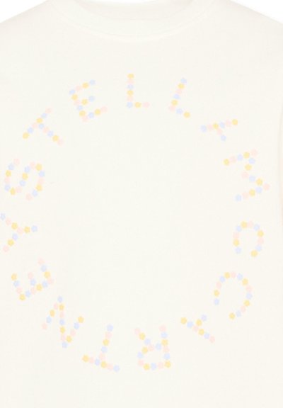 Tissu blanc avec un motif circulaire de petits hexagones pastel formant le mot "STELLA MCCARTNEY" autour du centre.