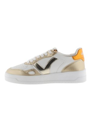 Baskets blanches et dorées métalliques avec un bout rond, des détails texturés et un accent orange contrastant au niveau du talon. Elles disposent de lacets blancs.