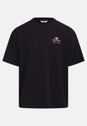 Zwart oversized T-shirt met ronde hals en kleine witte en rode grafische tekst op de linkerborst met de tekst "Revolutionary 2013 Pressure".