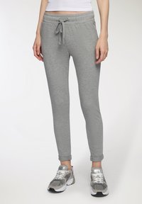 Pantaloni grigi in felpa con cintura regolabile, vestibilità slim e orli a coste. Realizzati in un tessuto morbido, presentano una texture liscia e un design minimale.