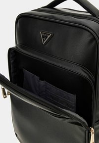 Zaino sintetico nero con texture, caratterizzato da un logo triangolare dorato e una tasca interna con scomparti per carte o documenti.