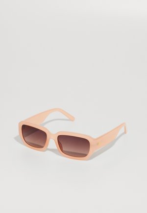 Lunettes de soleil couleur pêche avec une monture carrée, finition brillante et verres sombres dégradés. Design simple avec des branches droites et un détail de logo subtil.