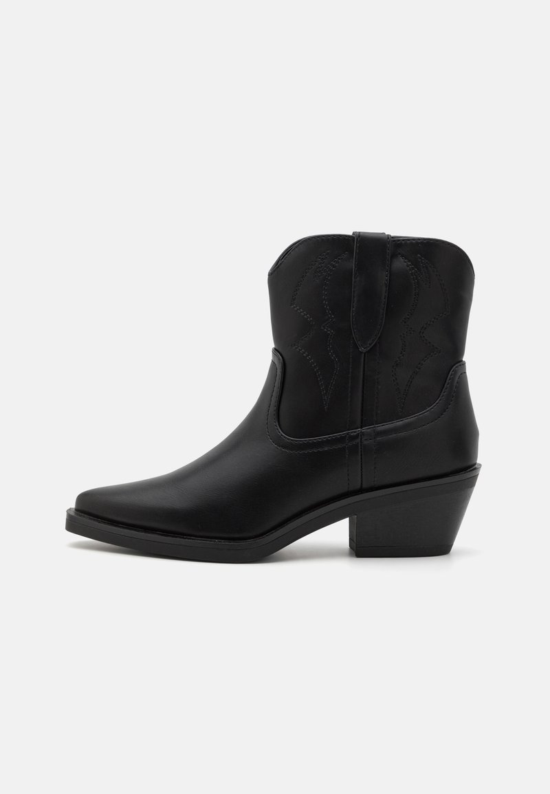 Botas de cowboy em couro preto com bicos pontiagudos, um salto curvado e detalhes em costura embutida. Textura lisa e design minimalista.