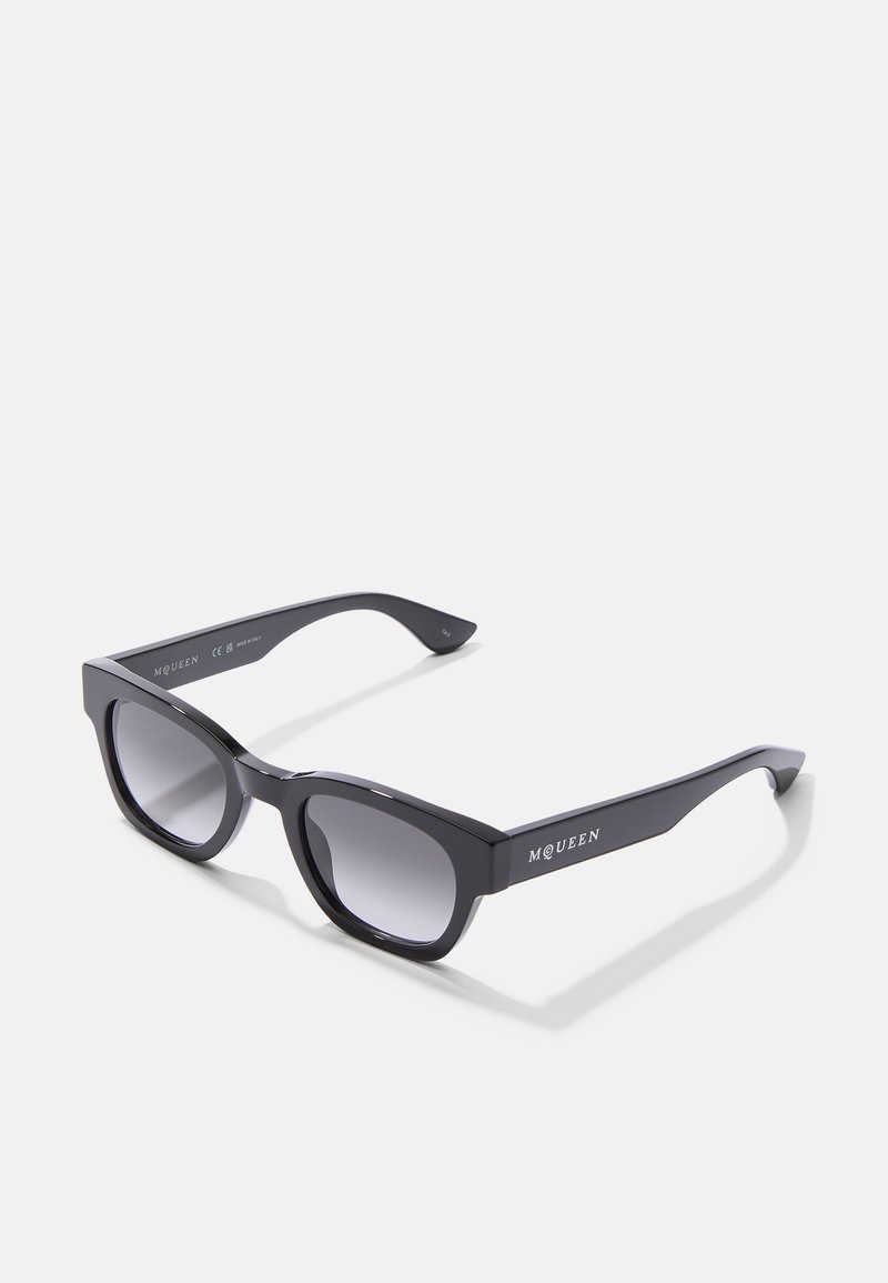 Mustad musta värvi prillid geomeetrilise raami, gradient objektiivide ja mattviimistlusega. Raamidel on brändi nimi "McQueen".