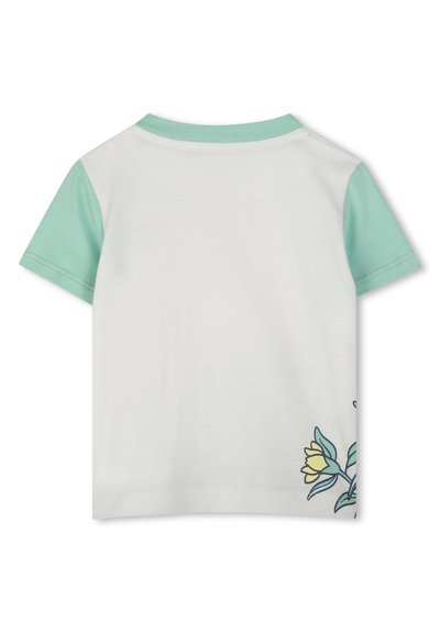 T-shirt à manches courtes avec un corps blanc et des manches vert menthe. Présente une broderie florale sur le côté gauche. Matière en coton doux.