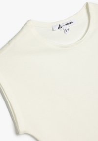 Crème-kleurige, getailleerde katoenen t-shirt met een ronde hals, korte mouwen en een klein merklabel op de halslijn. Soepele textuur.