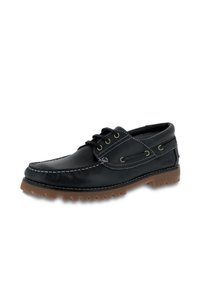 Scarpe da barca in pelle nera con cuciture bianche, design stringato, suola in gomma e profilo basso. Accenti includono occhielli e dettagli di branding.