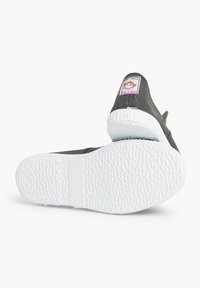 Šedá plátěná nazouvací bota s bílou gumovou podrážkou, která má barevnou etiketu na patě a texturovaný vzor na podrážce.