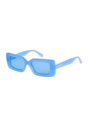 Lunettes de soleil rectangulaires bleu clair avec des montures épaisses translucides et des verres légèrement teintés, présentées en angle sur un fond blanc.