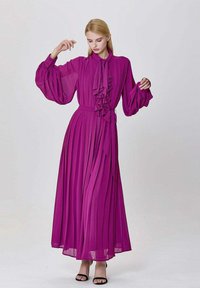 Longue robe plissée en violet vif avec un col montant, des détails volantés et des manches ballon, cintrée à la taille.