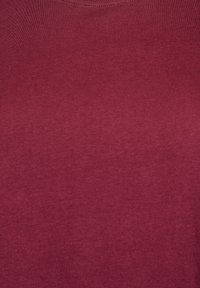 Burgundská tričko vyrobená z mäkkej bavlny. Má klasický okrúhly výstrih a hladkú textúru s minimálnymi švy.