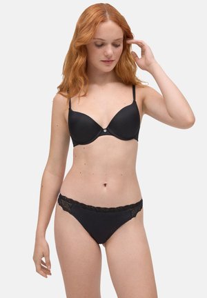 Sujetador negro con aros y copas lisas, acompañado de braguitas negras con detalles de encaje y una cinturilla suave.