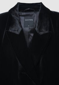 Schwarzer Samtblazer mit Satinfütterung, spitzen Revers und einem Etikett mit der Aufschrift "CALLIOPE", Größe S, der eine glatte Textur und klassisches Design zeigt.