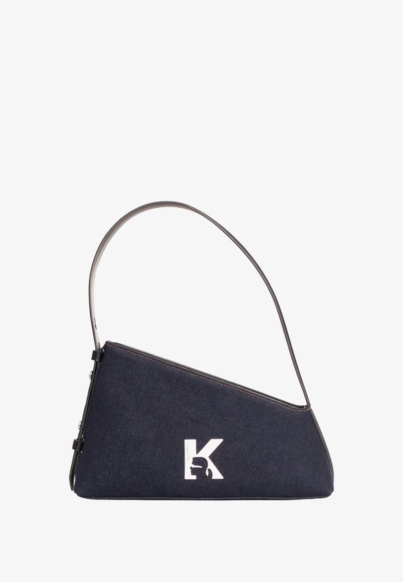 Sac à main triangulaire bleu foncé avec une fine bandoulière noire et un logo "K" blanc présentant une silhouette sur le côté avant.