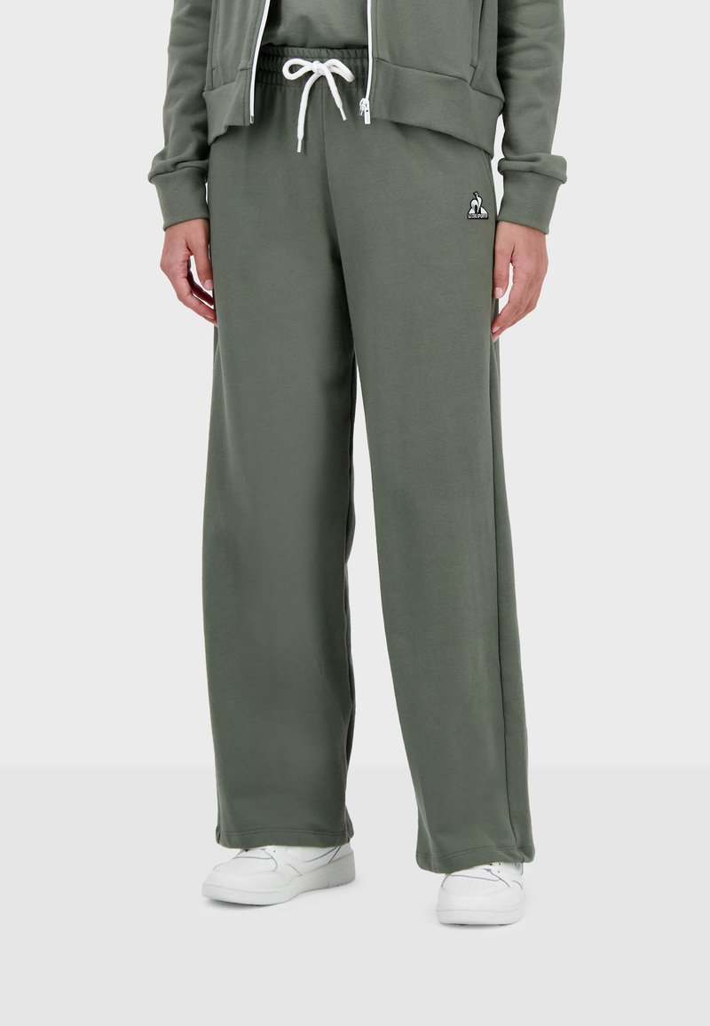 Groene sweatpants van zachte stof, met een trekkoord in de taille en een witte logo-accent. Het ontwerp heeft een relaxte pasvorm en is full-length.