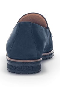 Scarpa in pelle blu con superficie liscia, tacco arrotondato e suola nera testurizzata. Presenta una piccola cerniera laterale e cuciture a contrasto.