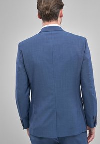Chaqueta de traje azul para hombre, hecha de tejido texturizado, con una abertura en la parte posterior, ajuste entallado y puños con botones.