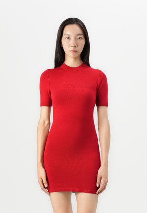Knit red dress with short sleeves, high neckline, and textured finish. Features subtle logo detail across the chest and fitted silhouette.