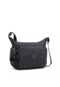 Black crossbody bag made of durable fabric featuring a textured surface, front zip pocket, and a furry keychain accent for added detail.