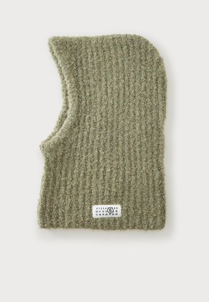 Cagoule tricotée verte avec une texture côtelée et une petite étiquette blanche avec des chiffres noirs sur le bord inférieur.