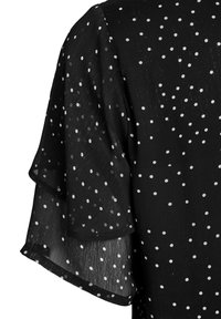 Czarna prześwitująca tkanina w białe groszki, z warstwowymi, falbankowymi rękawami o nieco teksturowanej powierzchni.