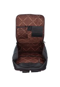 Interno dello zaino in pelle marrone, con rivestimento trapuntato, molteplici tasche e un ampio scomparto principale progettato per l'organizzazione.