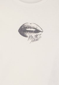 Biała bawełniana koszulka z czarnym graficznym wzorem w kształcie ust oraz napisem "Kiss Me Maybe?" w wyraźnej, stylizowanej czcionce. Miękka faktura, okrągły dekolt.