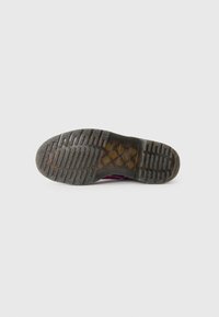 Semelle de chaussure en caoutchouc noir avec un motif de grip texturé, comportant des arêtes et des zones lisses. Légère avec un design durable.