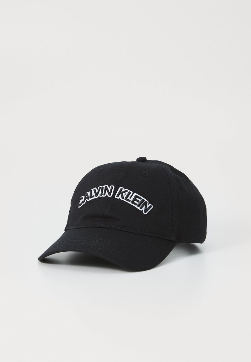 Čierna baseballová čiapka vyrobená z bavlny, s bielym vyšívaným textom "CALVIN KLEIN" na prednej strane a zakriveným šiltom.