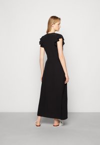 Vestido maxi preto com mangas curtas franzidas, corpete ajustado e saia fluida. Textura de tecido suave com um design minimalista.