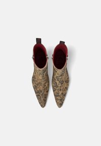 Botas de tobillo con estampado de leopardo, punta afilada, textura suave y interior rojo, con herrajes plateados y tiradores en los talones.