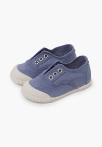 Scarpe slip-on in tela blu con punta testurizzata, aperture elastiche e occhielli argento. Il materiale è morbido, con suola in gomma.