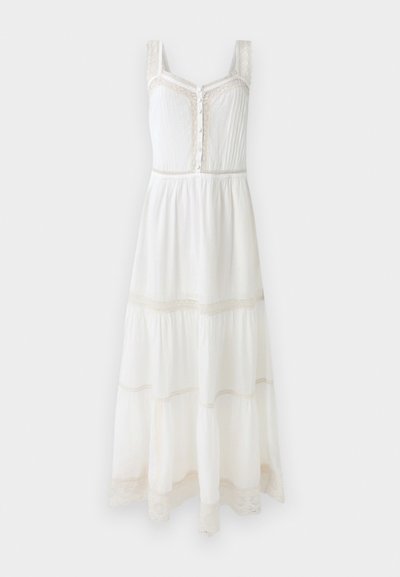 Vestido maxi blanco con acentos de encaje, cierre de botones y diseño en capas. Tejido ligero con detalles texturizados en las correas y el dobladillo.