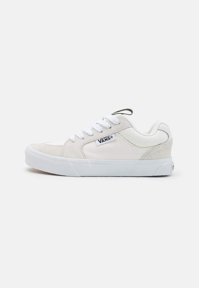 Baskets en toile blanches avec des accents en daim, bout arrondi, lacets plats blancs et un onglet vert sur la languette ; marquées du label "VANS".