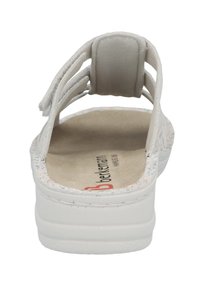 White back-strap sandal with a soft footbed, textured sole, and three adjustable straps. Features a logo on the inner sole and patterned accents.