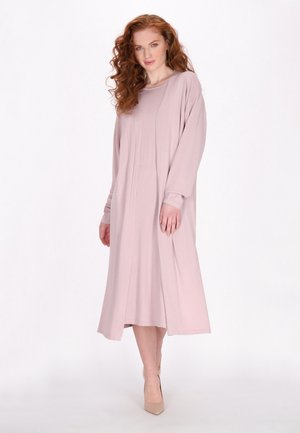 Pilota lungă, rochie din material roz moale, cu un croi lejer, hem până la genunchi și un model texturat subtil.