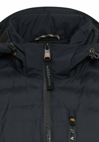 Zwarte geïsoleerde jas met een hoge kraag, ritssluiting aan de voorkant en een capuchon met trekkoord. Gemanierd materiaal met subtiel ruitpatroon en reflecterende accenten.